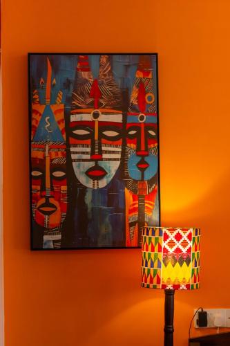 a painting hanging on a wall next to a lamp at Trisan Resident Hotel in Nairobi