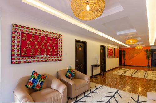 a living room with two chairs and a red rug at Trisan Resident Hotel in Nairobi