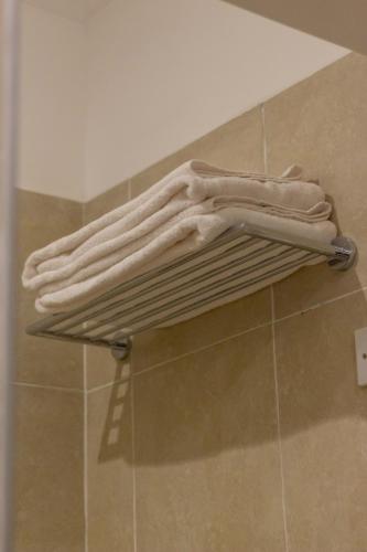 a pile of towels on a shelf in a bathroom at Trisan Resident Hotel in Nairobi