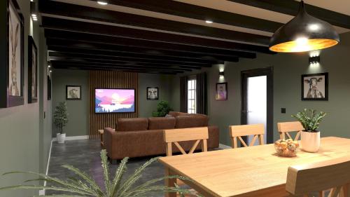 a living room with a couch and a tv at Talland Cottage 4 bedroom with Hot Tub in Looe