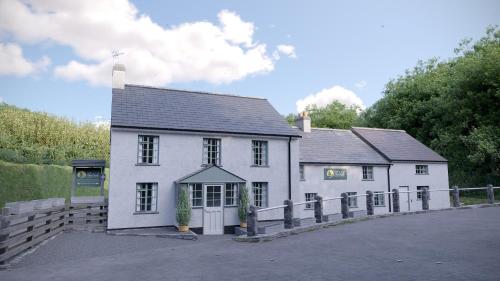 a white house with a fence in front of it at Lanreath Cottage 3 bedroom with Hot Tub in Looe