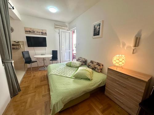 una camera da letto con un letto e un tavolo con sedie di Happy Time Studio a Petrovac na Moru
