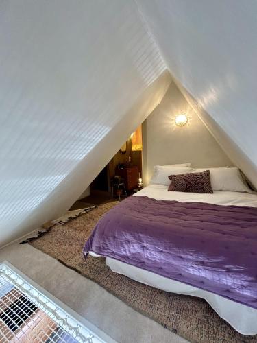 une chambre avec un lit dans un grenier dans l'établissement Nid des falaises, à Varengeville-sur-Mer