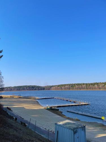 a dock in the middle of a large body of water at Leśny Zakątek - Domek nad samym jeziorem in Gołdap