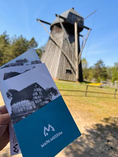 a person holding a card with a windmill in the background at Forest Mood in Wieck