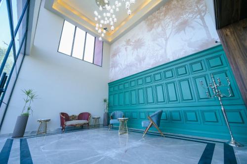 a room with a green wall with chairs and tables at Clarks Safari Haridwar in Haridwār
