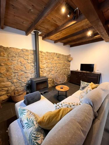 a living room with a couch and a stone wall at El Refugio de Júlia in Mier
