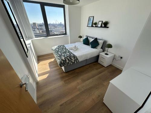a bedroom with a bed and a large window at Two Bedroom City View Apartment Liverpool in Liverpool