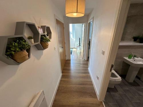 a hallway of a bathroom with a toilet and a sink at Two Bedroom City View Apartment Liverpool in Liverpool