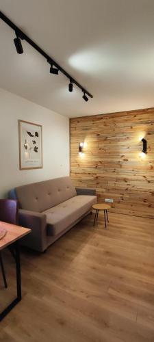 a living room with a couch and a wooden wall at Wooden Dream with Terrace in Siedlce