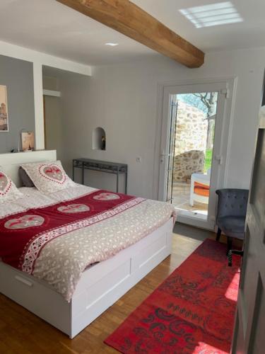 - une chambre avec un lit et une porte donnant sur une terrasse dans l'établissement MAISON 24 heures Mans, à Yvré-lʼÉvêque