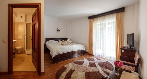 a bedroom with a bed with a dog on it at Pension Perla Bucovinei in Voronet