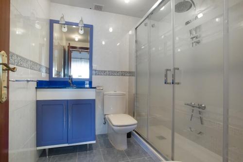 a bathroom with a toilet and a glass shower at Spacious Villa with Pool Plentzia Bilbao Area in Mendiondo