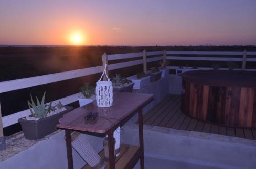 a balcony with a table and a sunset in the background at GIARDINO del MARE in Petrosino