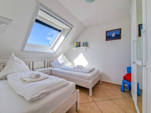 due letti in una stanza con finestra di Nordseeluft a Greetsiel