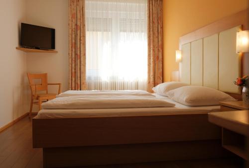 a bedroom with a large bed with a window at Pension zur Sonne in Illmitz