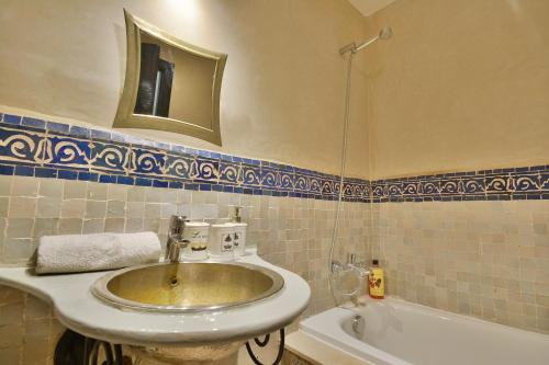 马拉喀什Oasis de l'Atlas by Golf Resort的带水槽、镜子和浴缸的浴室