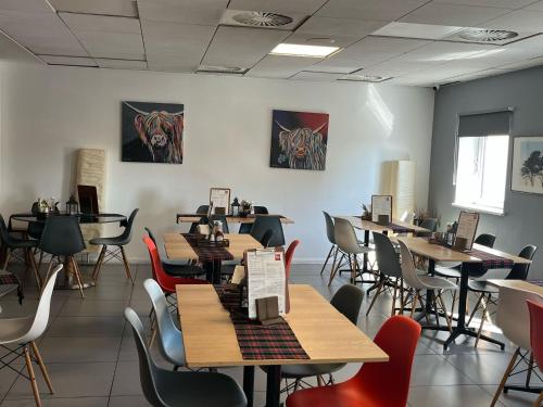 a dining room with wooden tables and chairs at ibis Aberdeen Centre – Quayside in Aberdeen