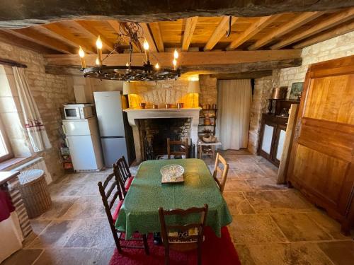 a kitchen with a table and chairs and a fireplace at Les gardiens d'antan in Béru