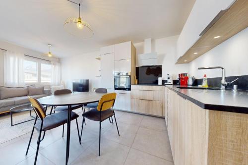 une cuisine et un salon avec une table et des chaises dans l'établissement Le Concert - Confortable 3 pièces de 60 m proche lac et Vieille Ville, à Annecy