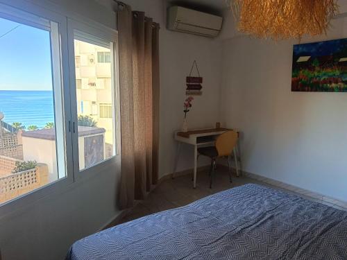 a bedroom with a bed and a desk and a window at Apartment Palasiet in Villajoyosa