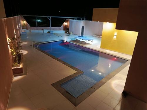 a large swimming pool in a building at night at شاليه الاميرات in Sowayma