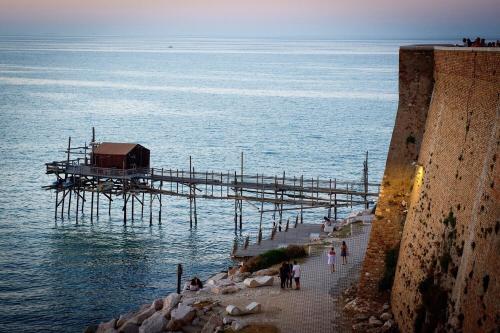 a pier in the water with people walking on it at La Perla dell' Adriatico Apartments - Perla Aurea - in Termoli