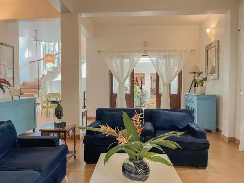 a living room with a blue couch and a table at Rainforest - Casa Azure 5 Min walk to the beach in Calangute