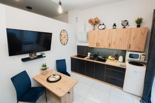 a kitchen with a table and a kitchen with a tv at Apartament GÓRSKIE MAZURY w Lagunie Beskidów in Zarzecze