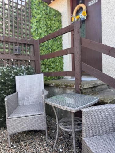 two chairs and a table and a table and a fence at Clunebeg Retreat in Spean Bridge