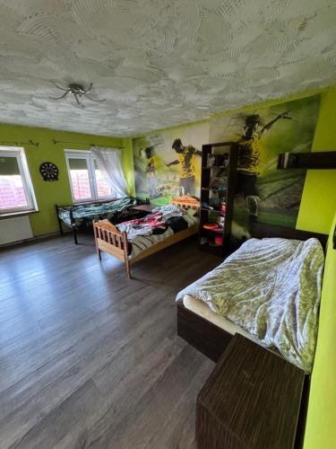 a bedroom with two beds in a room with green walls at Apartament na spokojnej wsi in Trzebiel