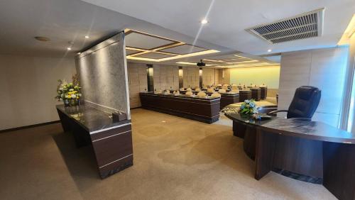a conference room with a row of desks in a room at Sky dome resotel - โรงแรมสกายโดม รีโซเทล in Bangkok
