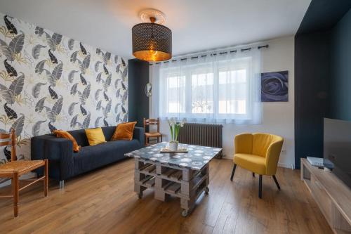 a living room with a couch and a table at Le Jovia - Cour extérieure - Wifi in Laval