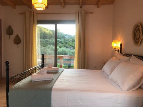 een slaapkamer met een groot bed met twee handdoeken erop bij Kiparissi Guesthouse in Himare