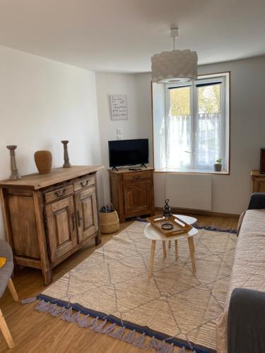 una sala de estar con un sofá y una mesa en Le Refuge, en Semide
