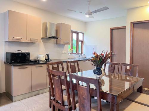 a kitchen with a wooden table and chairs and a kitchen with a counter at Rainforest - Casa Azure 5 Min walk to the beach in Calangute