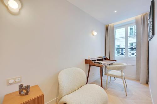 Cette chambre comprend une chaise, un bureau et une fenêtre. dans l'établissement Quartier Libre Madeleine, à Paris