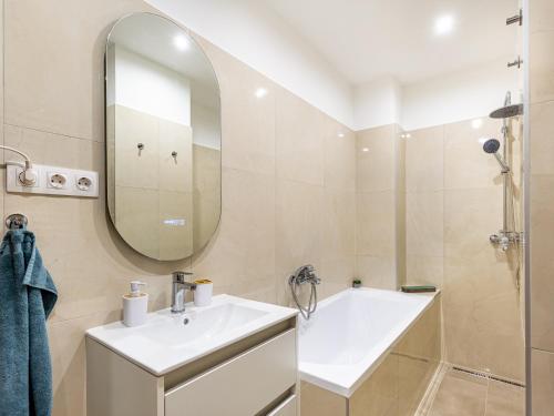 a bathroom with a sink and a mirror at Berliner Apartman by Mital in Szeged