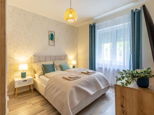 a bedroom with a large bed and a window at Berliner Apartman by Mital in Szeged