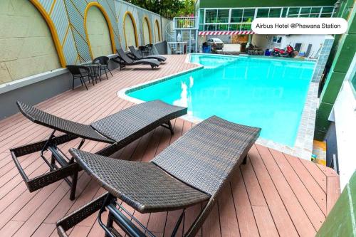 a deck with chairs and a swimming pool at Airbus Hotel At Phawana Station in Bangkok