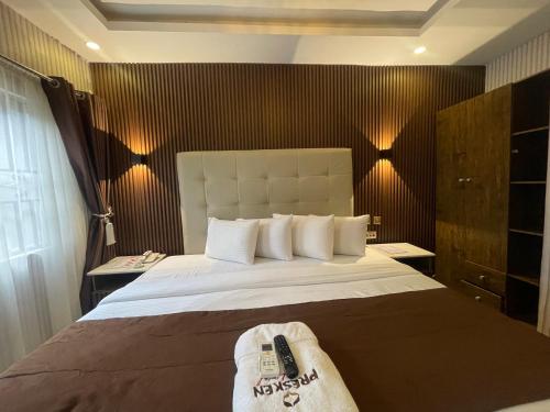 a bedroom with a bed with two remote controls on it at Presken Hotel @Villa in Ikeja