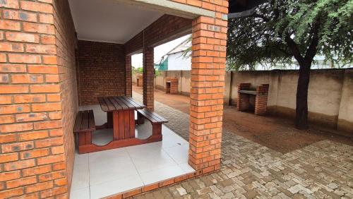 a brick wall with a bench on a patio at Pro Plants Accommodation in Kimberley