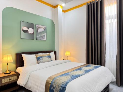 a bedroom with a large bed and a window at ORCHID Hotel in Da Lat