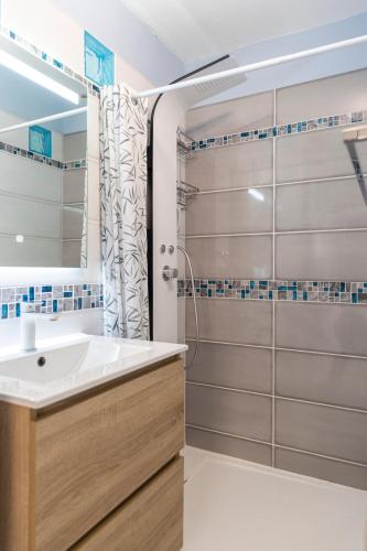 une salle de bain avec un lavabo et une douche dans l'établissement Le Nautilus, à Gruissan