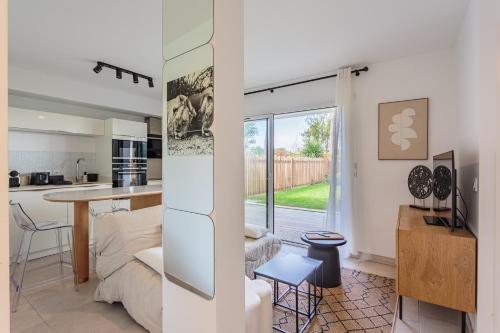 une cuisine et un salon avec une table dans la chambre dans l'établissement KARUKERA Bel appartement avec jardin au cœur de Chiberta, à Anglet