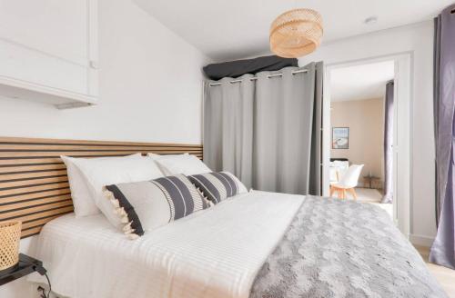 ラ・ボールにあるJolie Maisonnette avec terrasseの大きな白いベッドと枕のある寝室