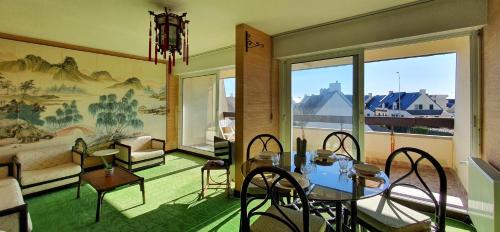 un salon avec une table, des chaises et un canapé dans l'établissement La Terrasse Ensoleillee, à Quiberon