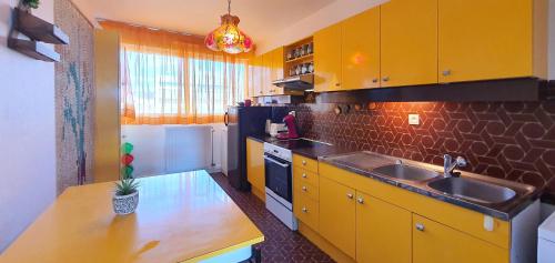 - une cuisine avec des placards jaunes et un évier dans l'établissement La Terrasse Ensoleillee, à Quiberon