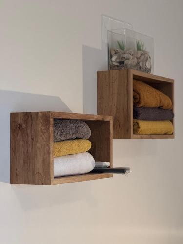 a pile of towels in wooden boxes on a wall at Rooms Kate in Krk