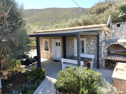a small stone house with a bench in a garden at Holiday Home Ruby in Sveti Jakov